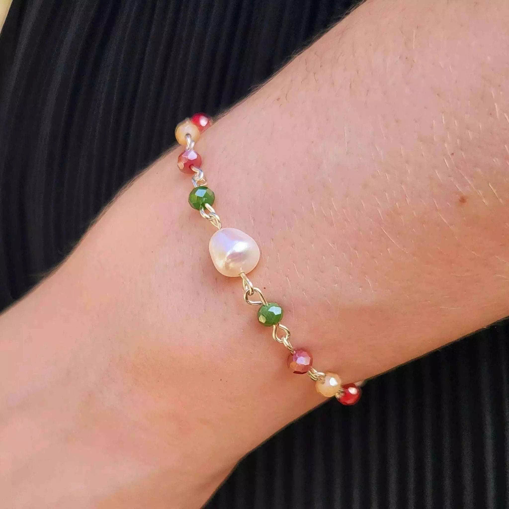 Bracelet en plaqué argent et perles d'eau douce et cristaux multicolores porté au poignet d'une jeune femme.