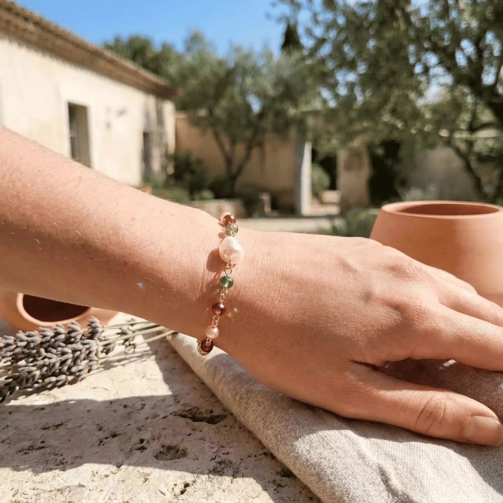 Bracelet en plaqué argent et perles cristal multicolores porté au poignet d'une femme.