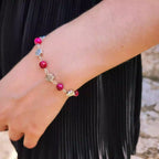 Bracelet pour femme ajustable en acier ou métal argenté avec perles rondes roses, porté délicatement au poignet.