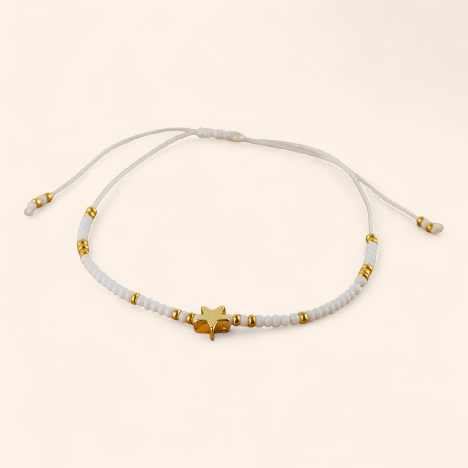 Bracelet en perles rocailles blanches et dorées avec perle étoile en métal doré  Bracelet Jethyka
