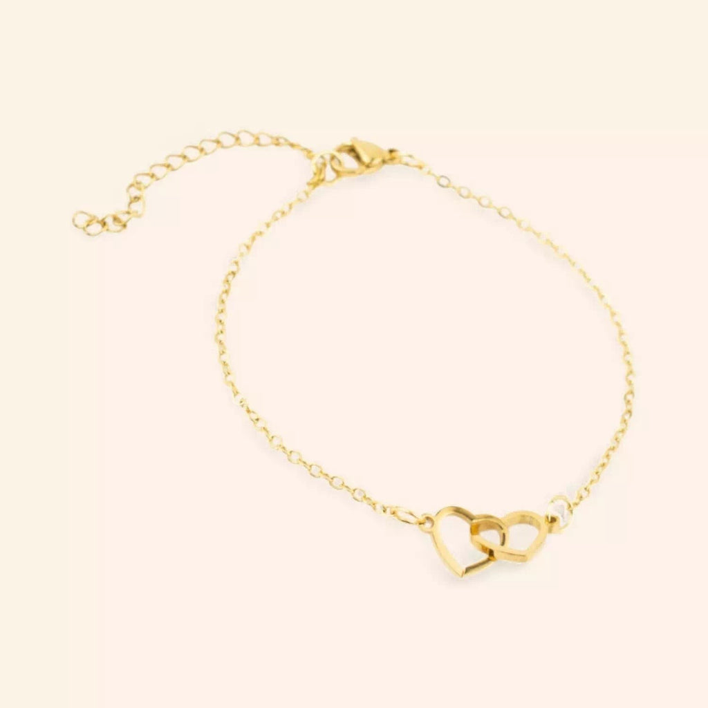 Bracelet JETHYKA doré avec deux cœurs entrelacés, chaîne fine réglable, bijou symbolique et élégant.