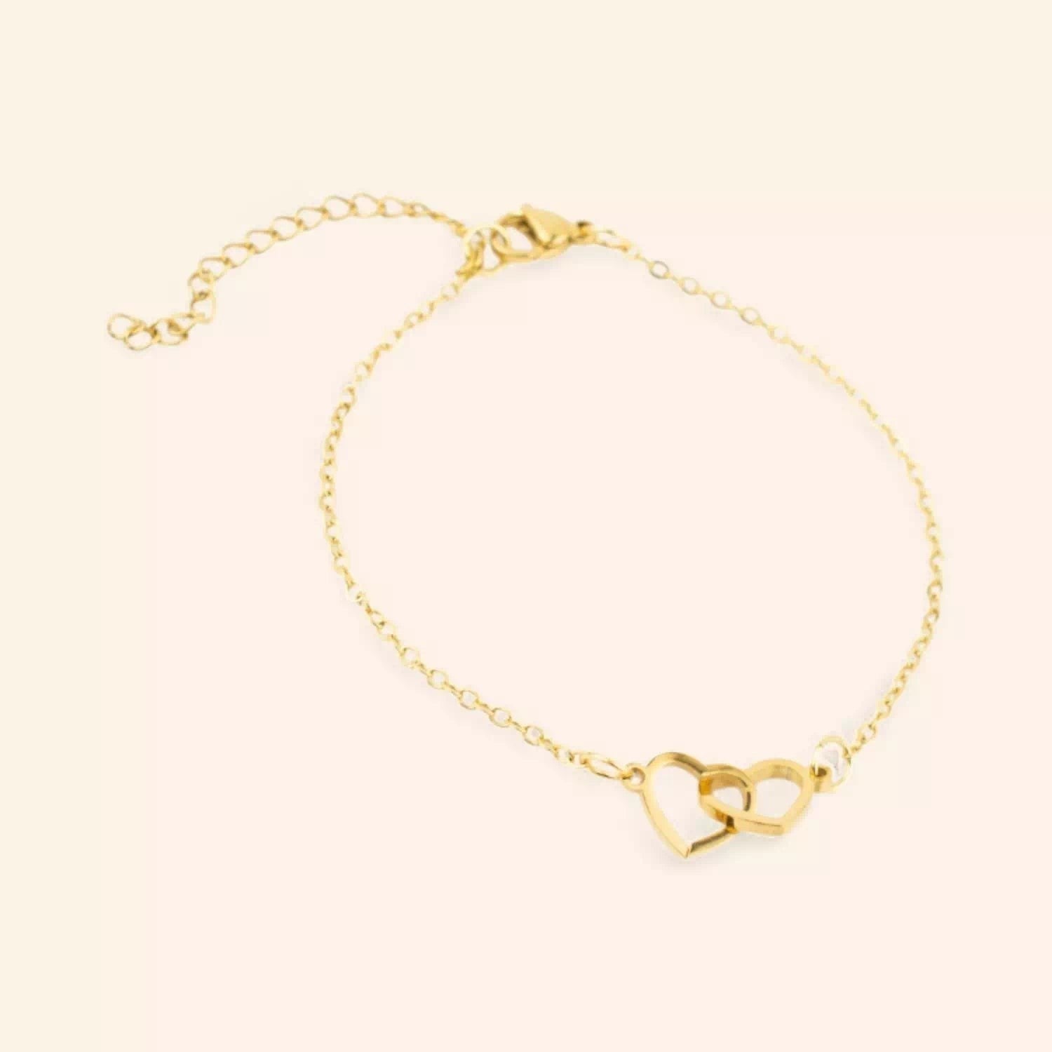 Bracelet JETHYKA doré avec deux cœurs entrelacés, chaîne fine réglable, bijou symbolique et élégant.