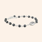 Bracelet JETHYKA Love en hématite naturelle, perles grises et breloque argentée, bijou élégant et énergétique.